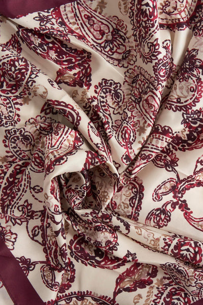 Foulard bordeaux en soie de MANGO, à motif cachemire imprimé, avec une bordure unie.
