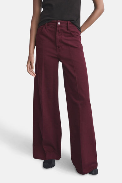 Jeans coloré bordeaux de MANGO, pantalon large porté avec un t-shirt noir uni.