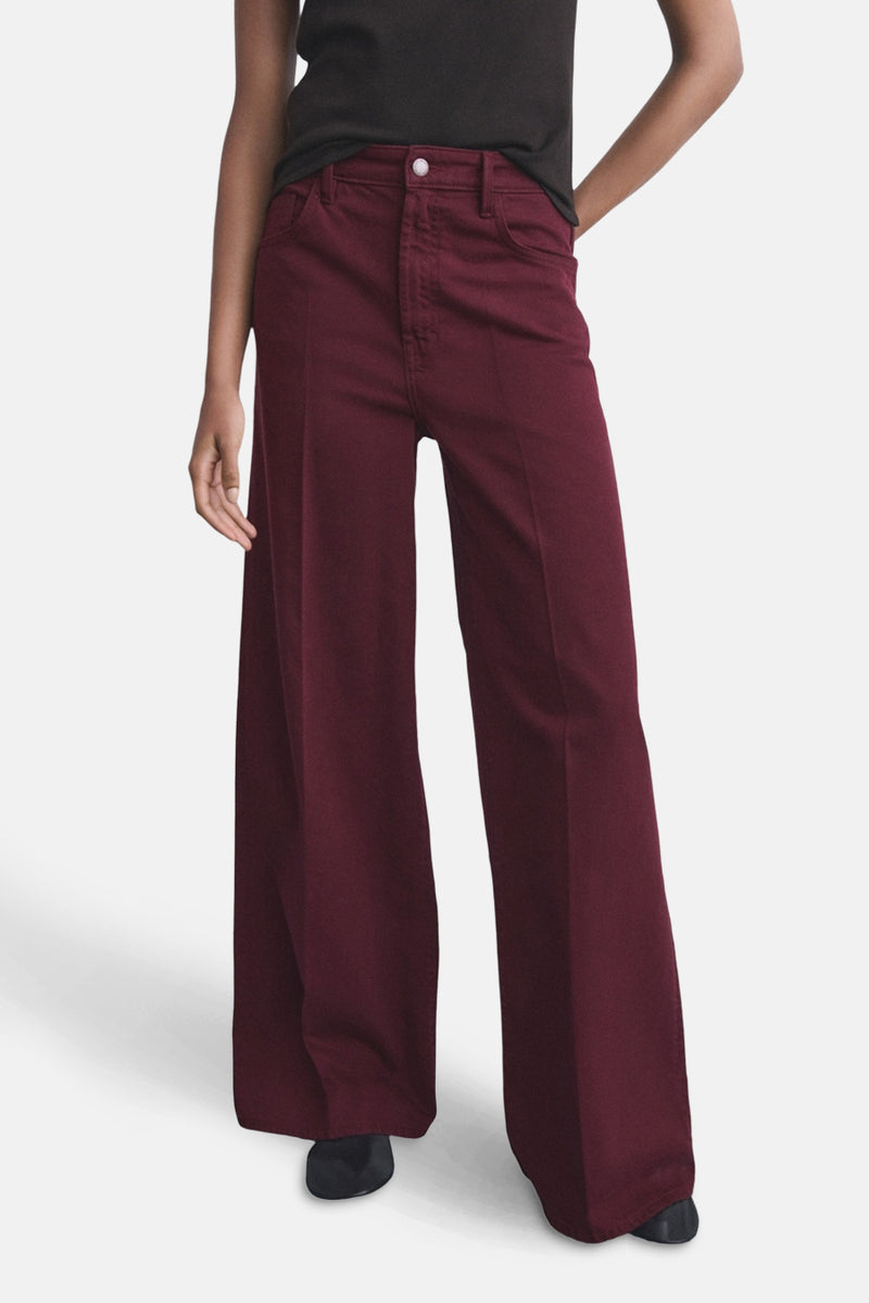 Jeans coloré bordeaux de MANGO, pantalon large porté avec un t-shirt noir uni.