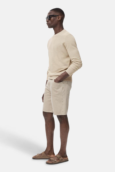 Beige ronde hals trui van MANGO, gedragen met een ton-sur-ton short en bruine sandalen, in zijdelings aanzicht.