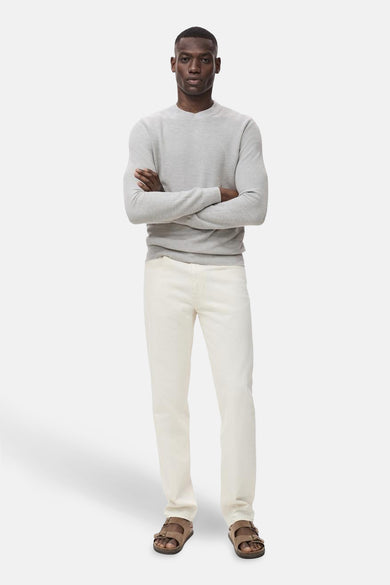 Grijze trui met ronde hals van MANGO, gedragen met gebroken witte jeans en bruine sandalen met twee bandjes.