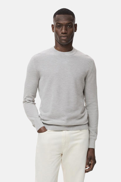 Grijze trui met ronde hals van MANGO, gedragen met een lichte broek.
