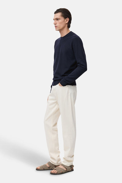 Ronde hals trui blauw van MANGO, gedragen met gebroken witte broek en gekruiste sandalen.