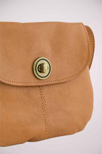 Bruine leren schoudertas van PIECES, met een ronde, verouderde metalen sluiting en zichtbare stiksels.