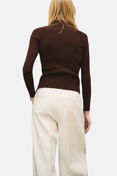 Bruin vest van MANGO, in ribgebreide stof, gedragen met een hoog getailleerde gebroken witte broek.