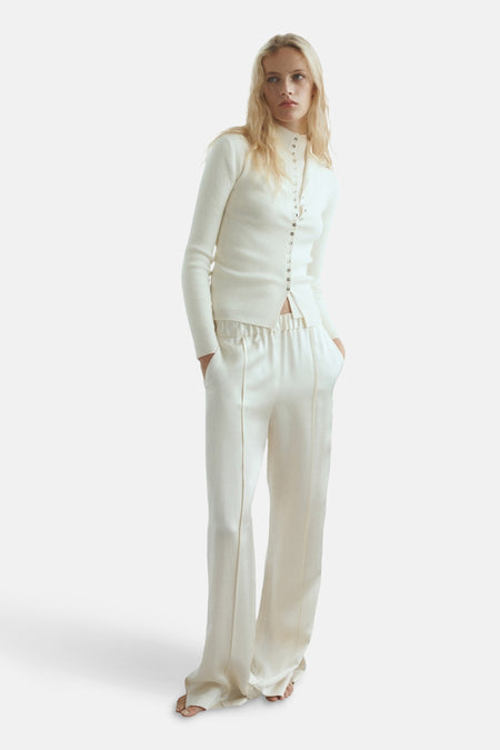 Beige gilet van MANGO, geribde gebreide stof met knoopsluiting aan de voorkant, gedragen met een broek met hoge taille.