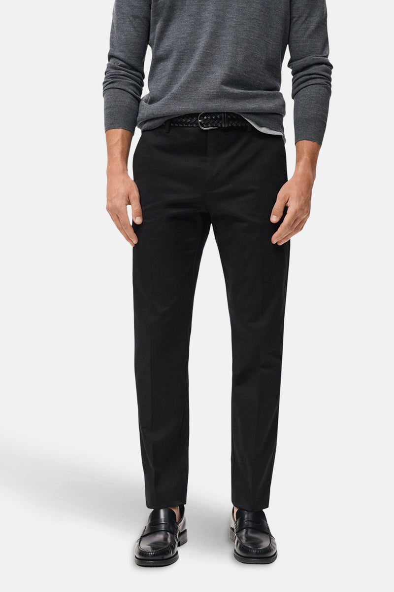 Donkerblauwe broek van MANGO met zwart gevlochten riem, gedragen met een grijptrui.