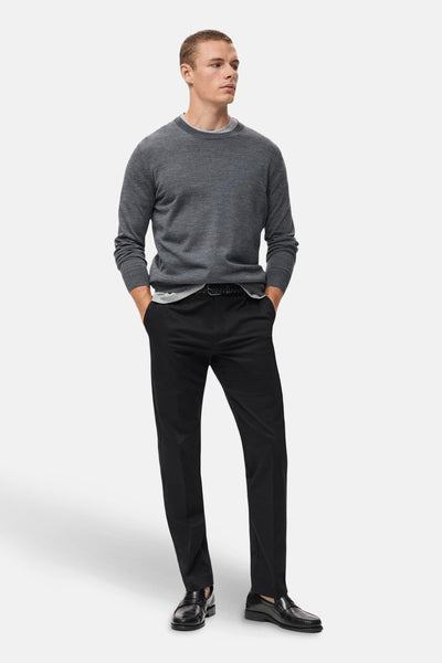 Donkerblauwe broek van MANGO, gedragen met een zwarte riem, vallend over zwarte loafers.