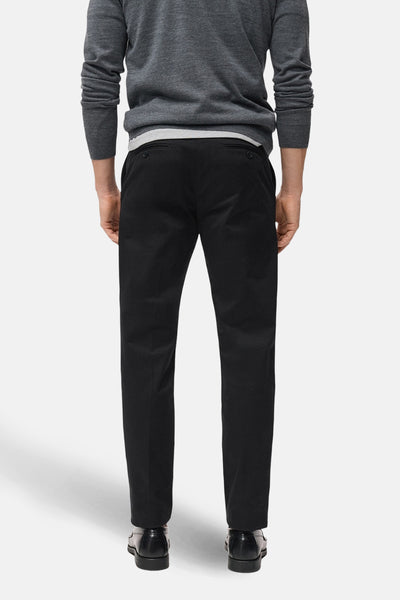 Donkerblauwe broek van MANGO, rechte pasvorm, gedragen met een grijve trui met lange mouwen, achterzicht.