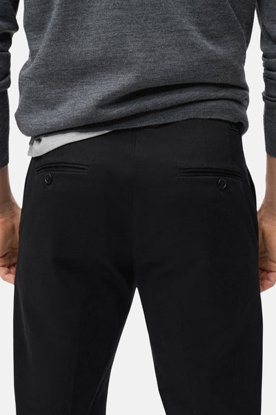 Pantalon de saison bleu foncé de MANGO, avec poches arrière passepoilées et boutons.