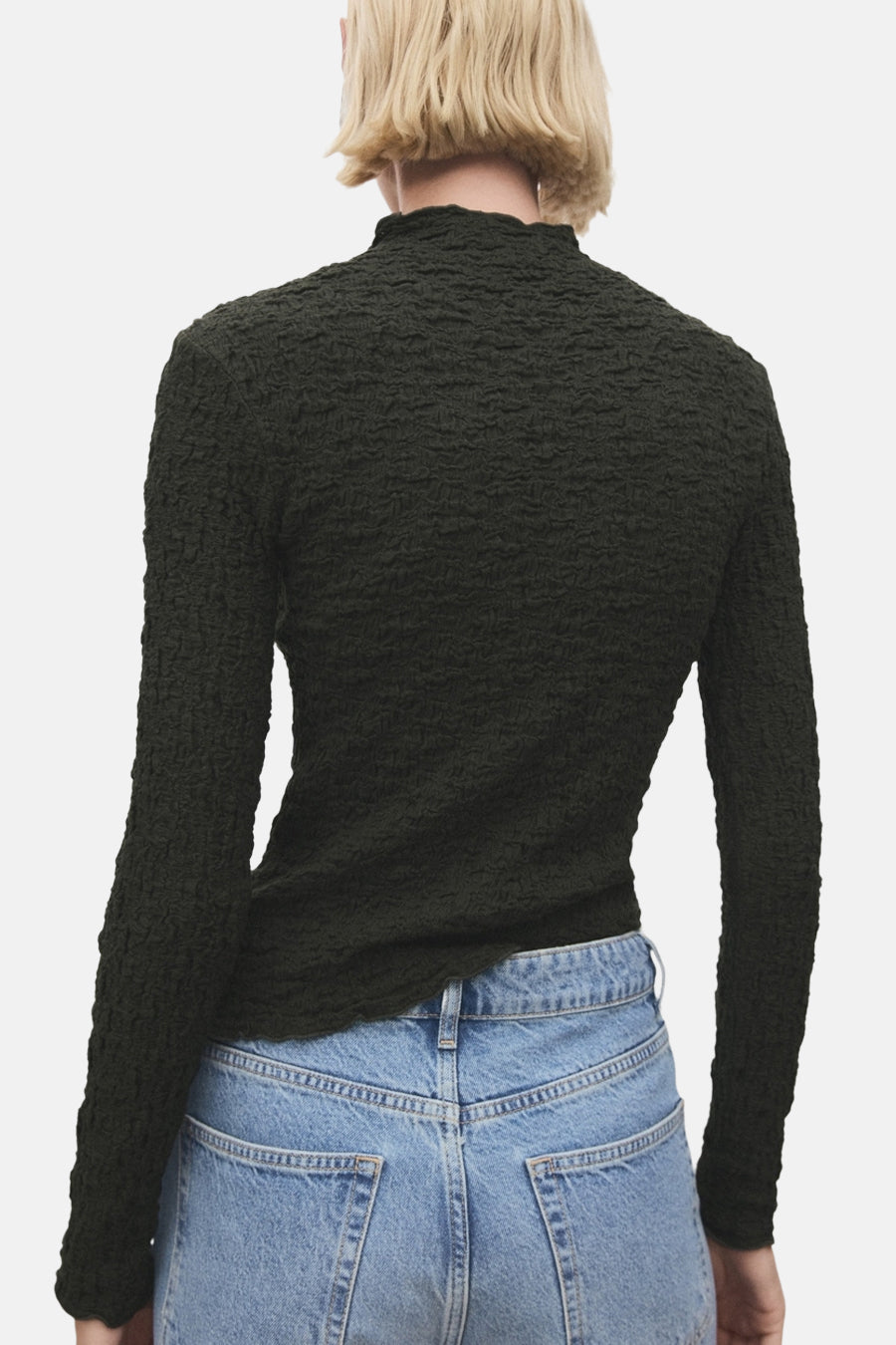 T-shirt kaki texturé à manches longues de MANGO, détail du dos, porté avec un jean bleu taille haute.
