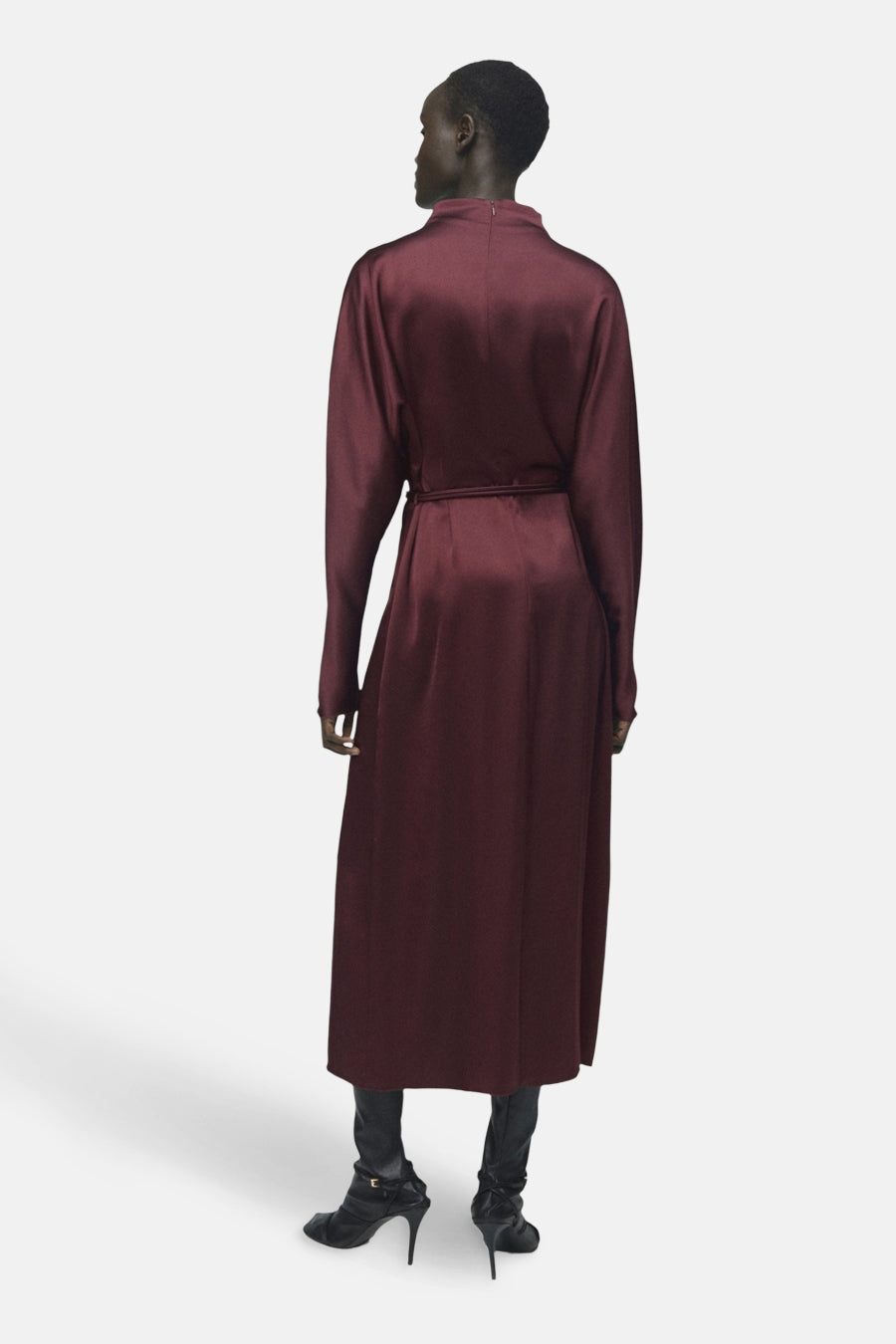 Robe bordeaux à manches longues de MANGO, avec une ceinture ton sur ton et portée avec des bottines noires.

