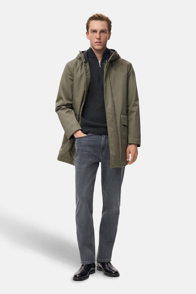 Veste courte kaki de MANGO, portée sur un pull gris foncé, avec un jean gris et des chaussures noires.