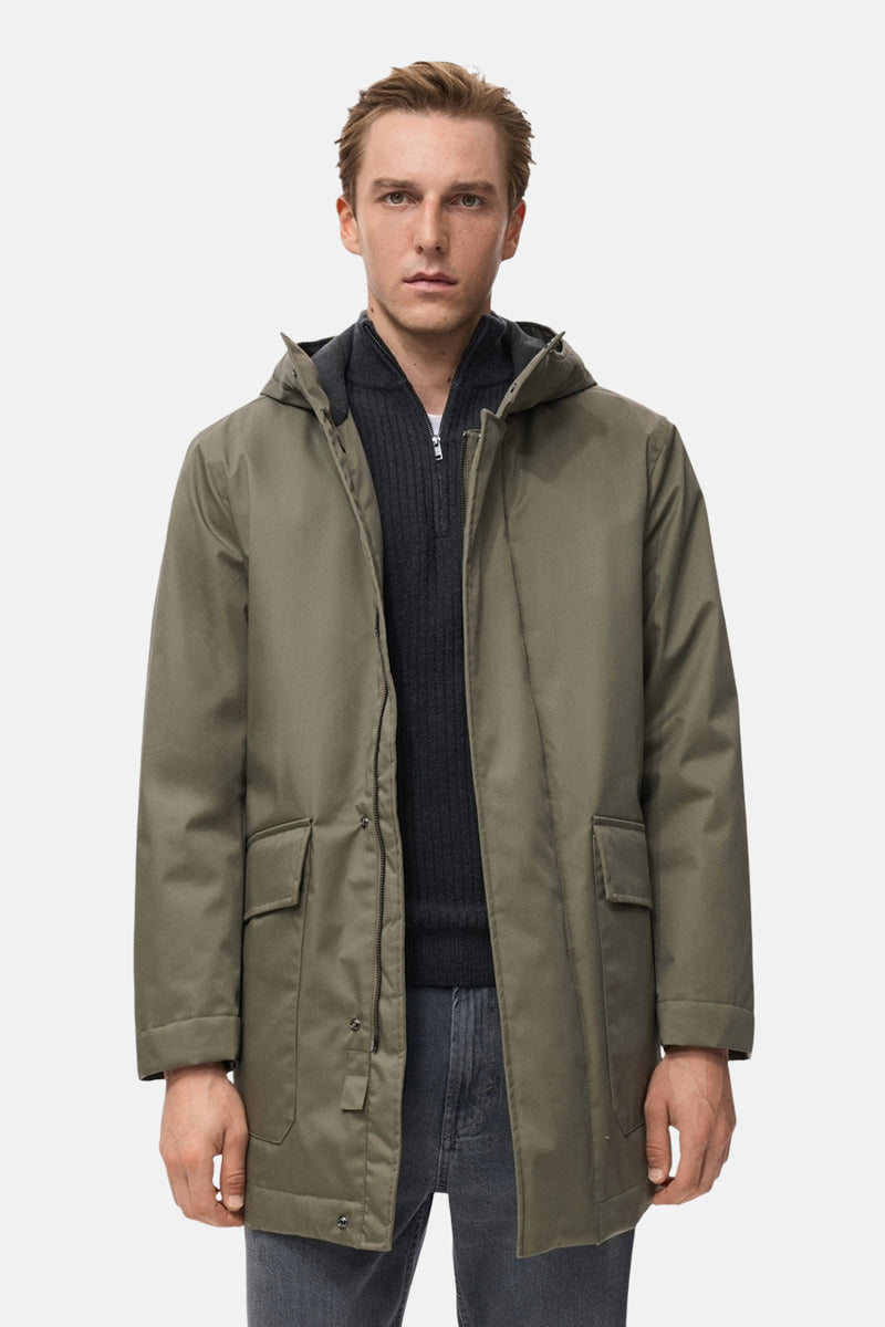 Veste courte kaki de MANGO, avec capuche et fermeture à zip, portée sur un pull gris et un jean.
