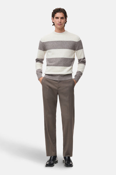 Pull à col rond multicolore de MANGO avec rayures horizontales et manches longues, porté avec un pantalon marron.
