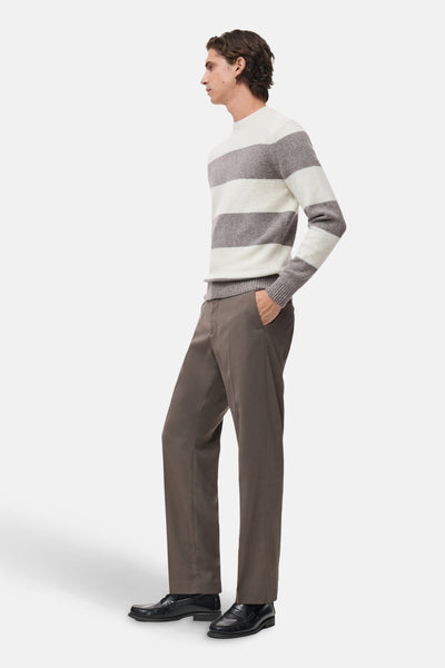 Pull à col rond multicolore de MANGO, à rayures horizontales, porté avec un pantalon marron et des mocassins noirs.
