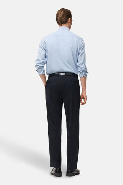 Chemise à manches longues bleue de MANGO, portée avec un pantalon noir et des chaussures en cuir, vue de dos.