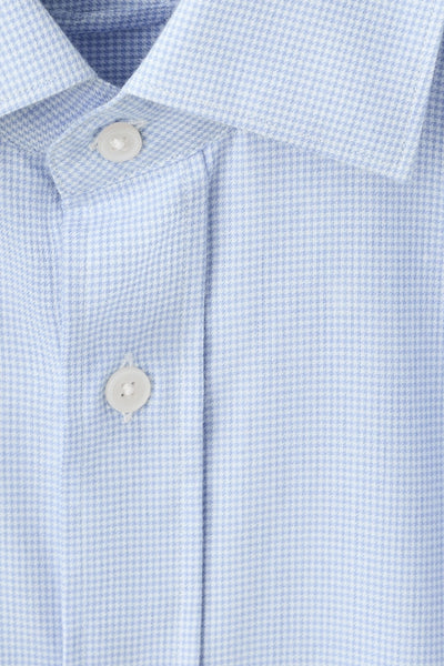 Chemise à manches longues bleue de MANGO, motif pied-de-poule, avec boutons apparents et col classique.