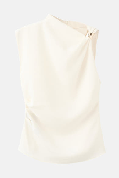 Blouse écrue sans manches de MANGO, avec un col montant et un détail métallique à l'épaule.