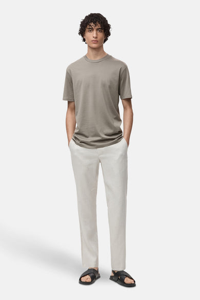 Grijze T-shirt met korte mouwen van MANGO, gedragen met een beige broek en zwarte sandalen.