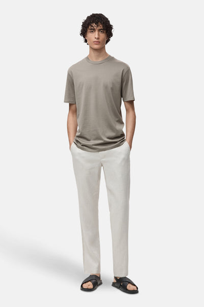Grijze T-shirt met korte mouwen van MANGO, gedragen met een beige broek en zwarte sandalen.