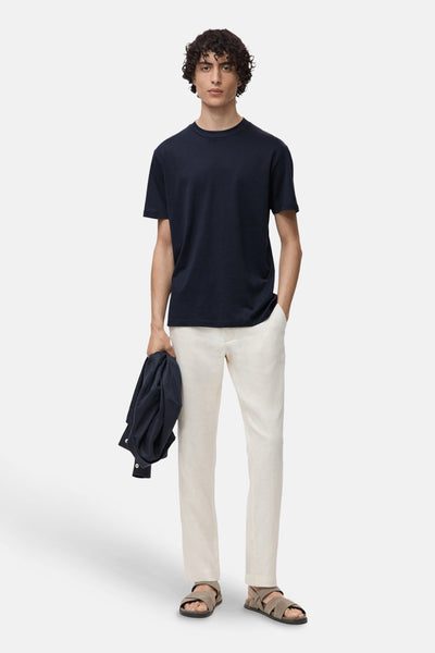 Blauw T-shirt met korte mouwen van MANGO, gedragen met een beige broek en leren sandalen.