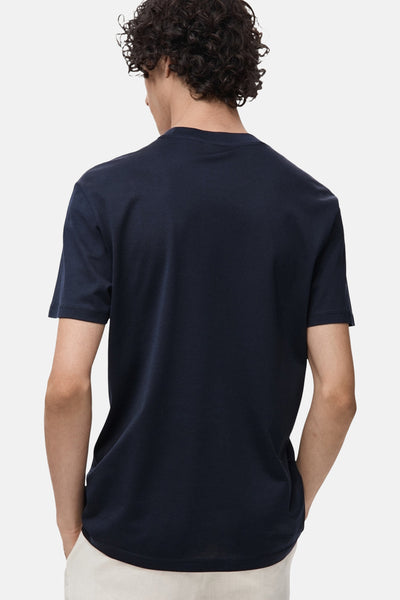 Blauwe T-shirt met korte mouwen van MANGO, van achteren gezien, gedragen met een beige broek.