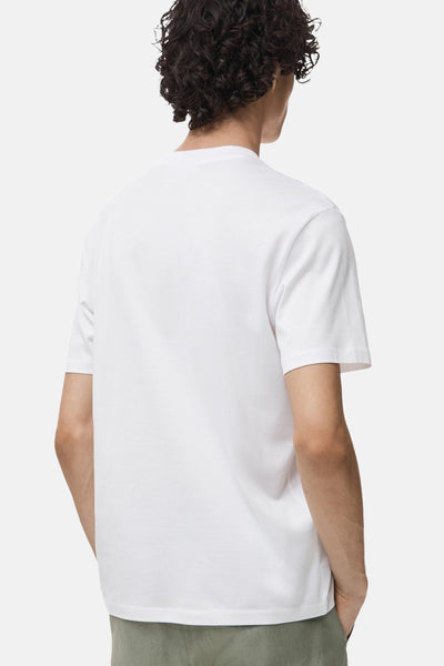 T-shirt à manches courtes blanc de MANGO, vu de dos, porté avec un pantalon vert olive.