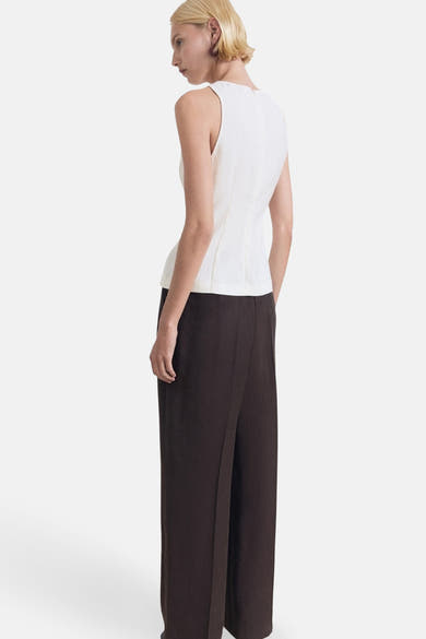 Ecru mouwloos blouse van MANGO, gedragen met een wijde chocoladebruine broek.