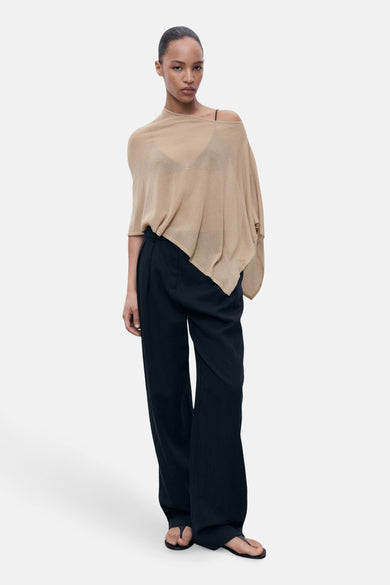Beige ronde hals trui van MANGO, gedragen met een wijde zwarte broek en minimalistische sandalen.
