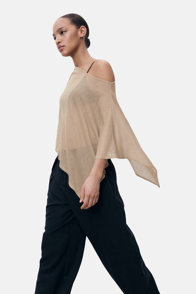Pull à col rond beige de MANGO, avec une épaule dénudée, porté avec un pantalon noir ample.