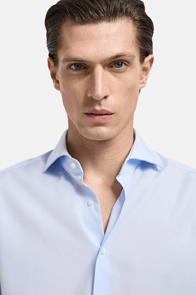 Chemise à manches longues bleue de MANGO, avec une coupe classique et un col boutonné.
