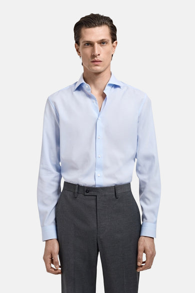 Blauw overhemd met lange mouwen van MANGO, gedragen met een donkergrijze broek.