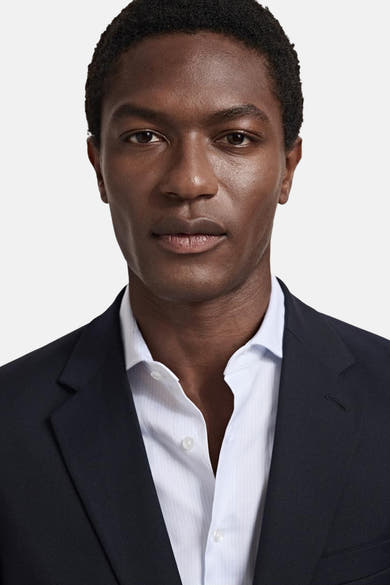 Blauwe blazer van MANGO met een gestreept overhemd aan bij een mannelijk model.