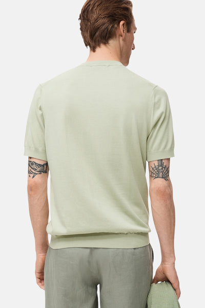 Groen T-shirt met korte mouwen van MANGO, met tatoeages op de armen, gedragen met een bijpassende broek.