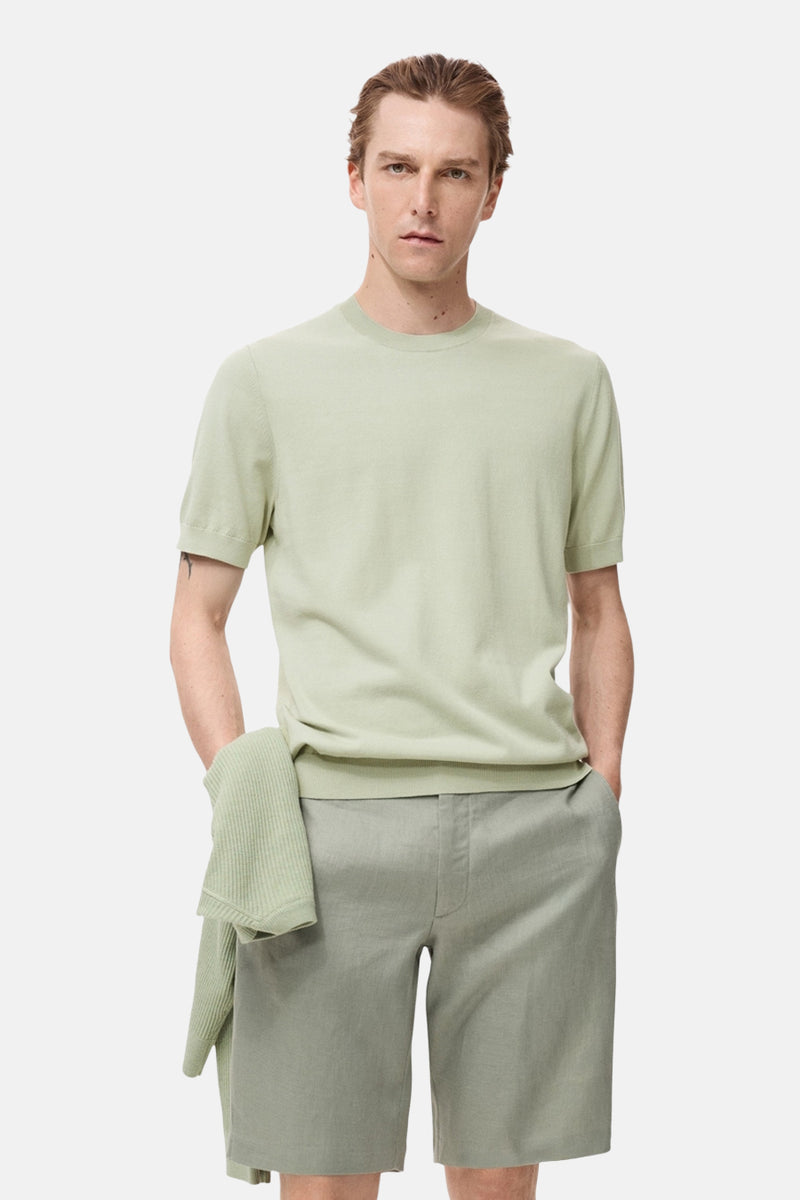 Groen T-shirt met korte mouwen van MANGO, gedragen met een bijpassende short en een trui over de schouder.