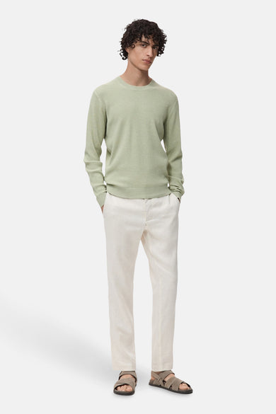 Groene trui met ronde hals van MANGO, getextureerd, gedragen met een gebroken witte linnen broek en sandalen.