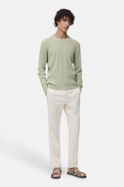 Groene trui met ronde hals van MANGO, getextureerd, gedragen met een gebroken witte linnen broek en sandalen.