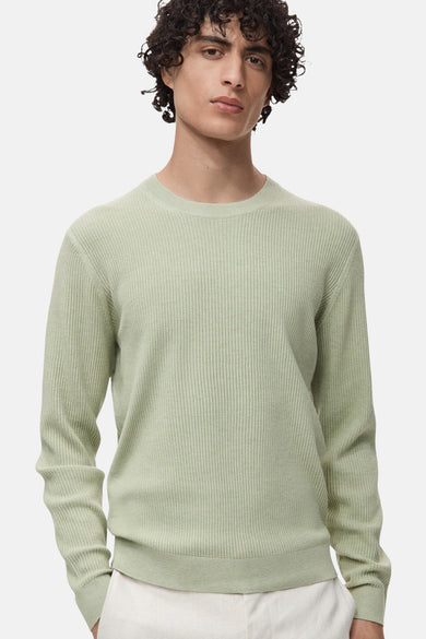 Groene trui met ronde hals van MANGO, in fijne ribgebreide stof, gedragen met een witte broek.