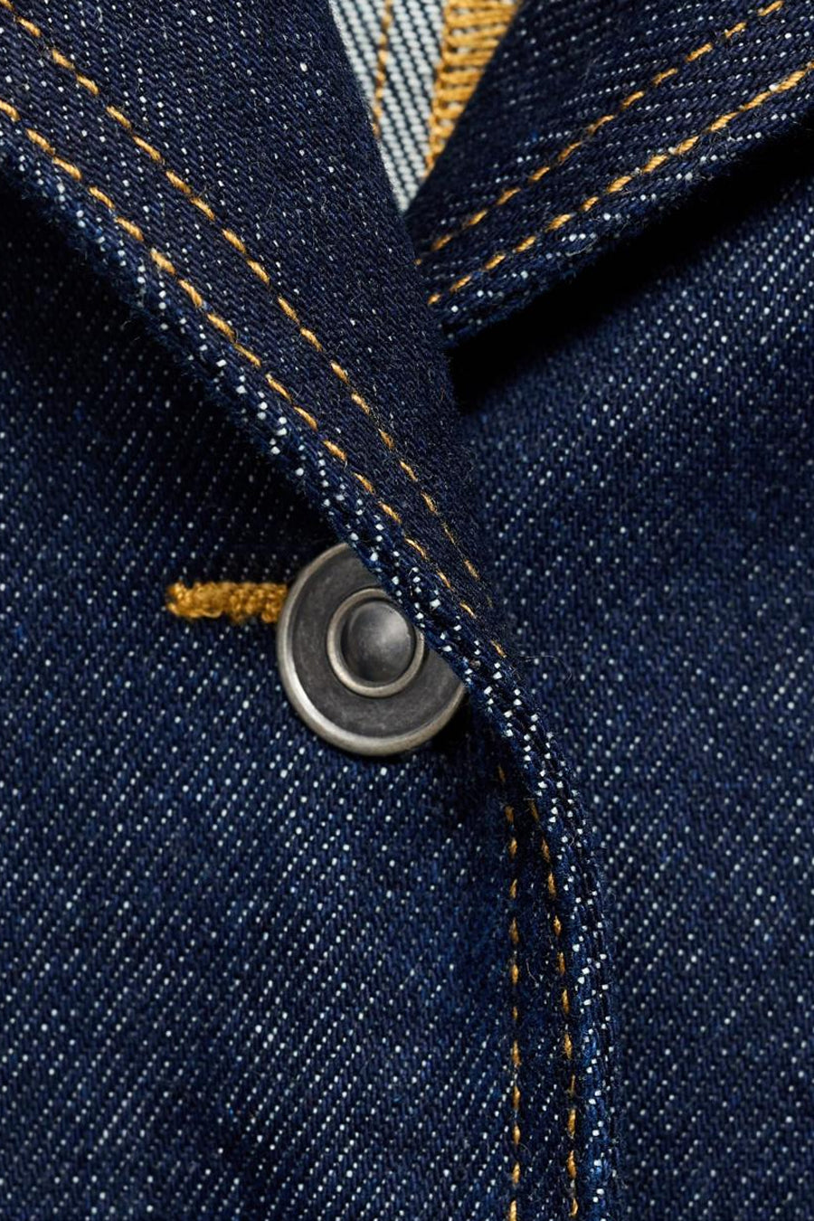 Veste en jean bleu foncé en denim de MANGO, avec bouton en métal et surpiqûres contrastantes.
