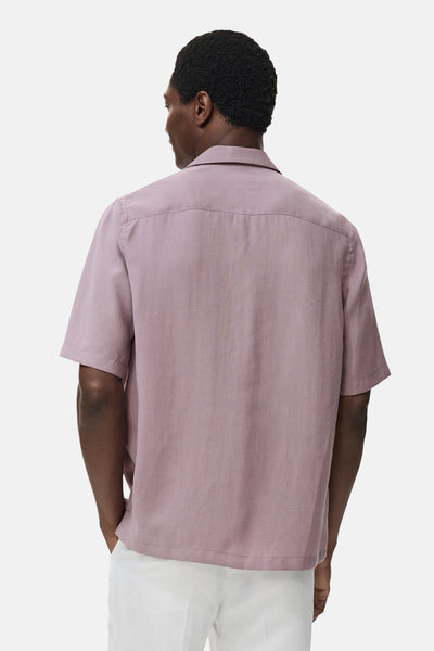 Paarse blouse met korte mouwen van MANGO, van achteren gezien, gedragen met een witte broek.