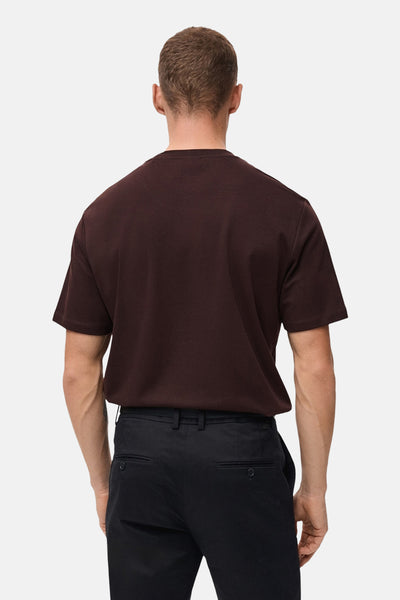 Bordeaux T-shirt met korte mouwen van MANGO, gedragen met een zwarte broek, achtergezicht.