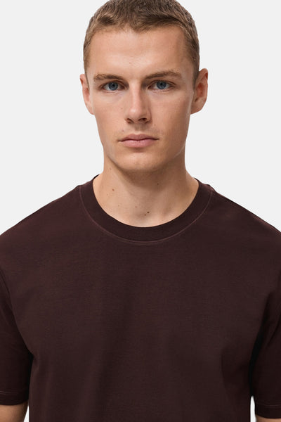 Bordeaux T-shirt met korte mouwen van MANGO, gedragen door een man met een lichte huidskleur.