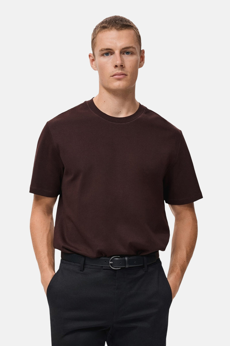 Bordeaux T-shirt met korte mouwen van MANGO, gedragen met een zwarte broek en een riem.