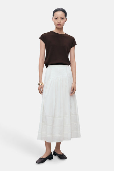 Bruine top van MANGO, gedragen met een lange witte rok en ballerina's.