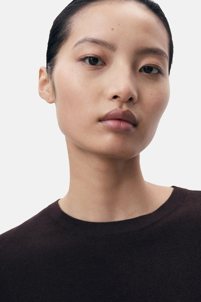 Top brun de MANGO, porté avec une peau lisse et des cheveux noirs tirés vers l'arrière.