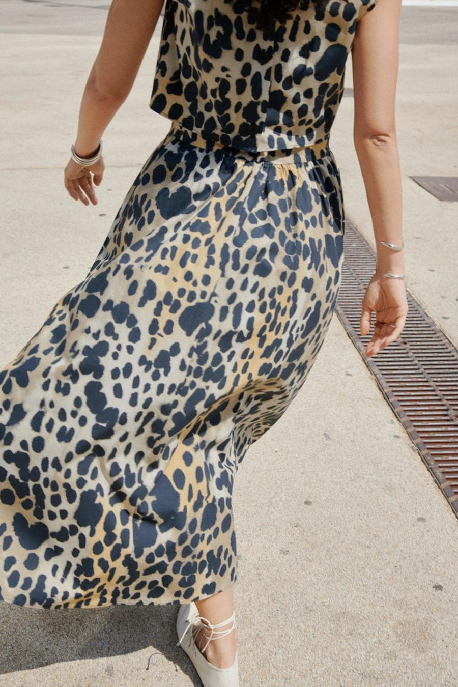 Multikleurige lange rok van MANGO, met luipaardprint, gedragen met platte veterschoenen.