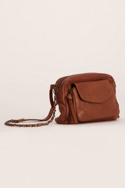 Sac à main en cuir brun par PIECES, avec une bandoulière en chaîne métallique et une poche avant à rabat.
