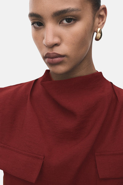 Bordeaux mouwloze blouse van MANGO, met gedrapeerde opstaande kraag en opgestikte zakken.