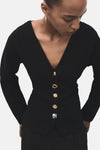 Cardigan noir de MANGO avec encolure en V, manches longues et boutons décoratifs.